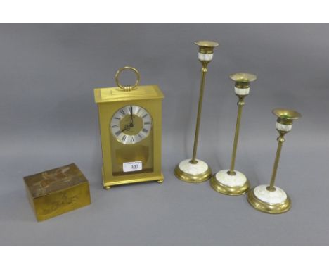 Brass wares to include a rectangular box and cover with horse and rider embossed pattern, three candlesticks and a mantle clo
