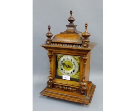 Oak cased mantle clock with urn finials to top above a gilt metal dial with silvered chapter ring with Arabic numerals, 45cm 