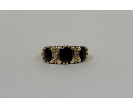 A sapphire and diamond ring, probably early 20th century, the three oval-cut graduated dark blue sapphires spaced by two line