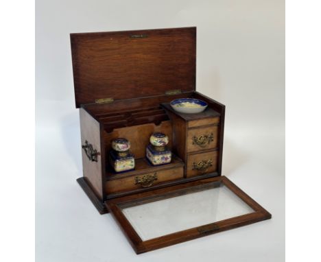 An Edwardian glazed oak stationery cabinet, with hinged caddy top and glazed fall front opening to an interior fitted with dr
