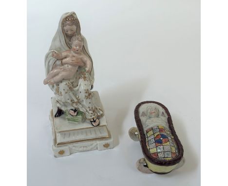 A Staffordshire pearlware crib group, c. 1800, the infant modelled lying under a patchwork quilt; together with a Duesbury &a