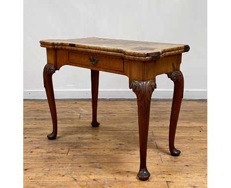A George II walnut fold over card table, the bur, cross banded, and ebony strung top with lobed corners, opening to a red bai