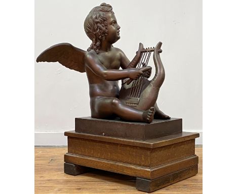 A large patinated metal figure of a putto playing a lyre, 20th century, on an integral rectangular base, unsigned. Height 64c