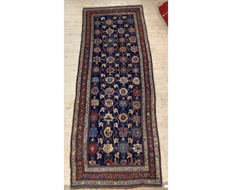 An antique Kurdish 'Blossom' design runner rug, third quarter of the 19th century, the blue field enclosed by border with mul