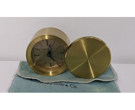 A Tiffany & Co travel alarm clock in a lacquered brass case with rotating cover, numbered 200570Location: 