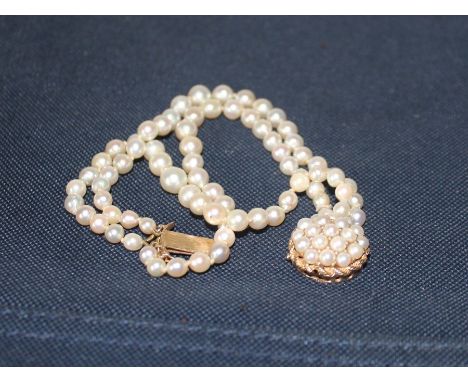 A 14ct. gold and triple row cultured pearl bracelet, having domed and pierced clasp set numerous cultured pearls, import hall