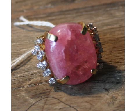 A 14ct, gold, pink tourmaline and diamond dress ring, four claw set large polished pink tourmaline, each side with nine gradu