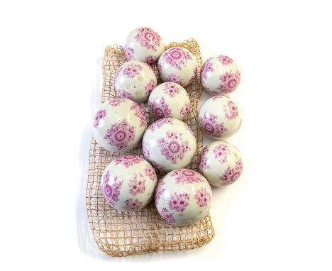 A set of eleven Victorian ceramic boules, transfer printed with pink flowers