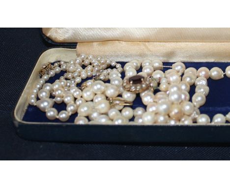 A graduated cultured pearl necklace, with 14ct. yellow gold textured oval clasp set blister pearl to either side, stamped "58