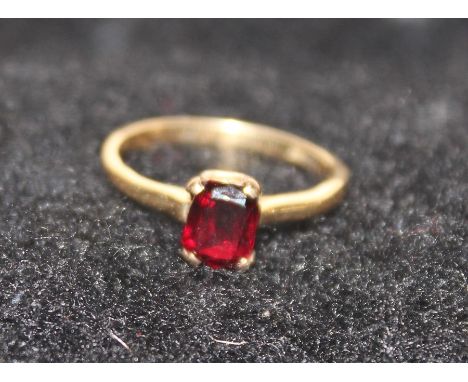 An 18ct. gold and garnet ring,&nbsp;claw set rectangular mixed cut deep red garnet, shank stamped "18ct". (gross weight 2.6g)