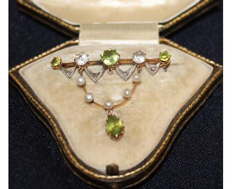 An Edwardian precious yellow metal, peridot, diamond, white stone and pearl set bar brooch,&nbsp;having bar set three graduat