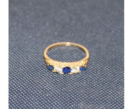 An 18ct. gold, diamond and sapphire five stone ring, set three graduated round cut sapphires alternating two old round cut di