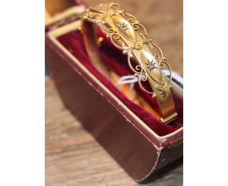 A 9ct. gold and diamond hinged bangle,&nbsp;one half having three navette form mounts with&nbsp;applied openwork borders, eac