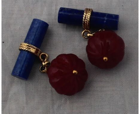 A pair of yellow metal, lapis lazuli and ruby cuff links,&nbsp;each having near spherical ruby to one side, carved with radia