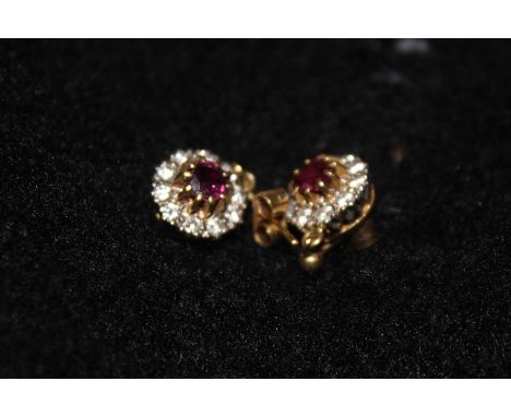 A pair of precious yellow and white metal, ruby and diamond cluster drop earrings,&nbsp;each set round cut ruby to centre bor