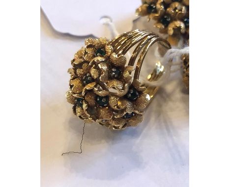 A precious yellow metal ring and a pair of earrings en suite, fashioned as flower clusters, with textured petals set green pa