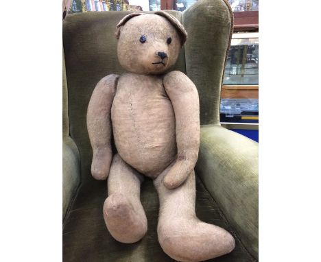 A large wartime teddy bear, early 20th century, unknown maker but in the style of Steiff, hump back, complete with photograph