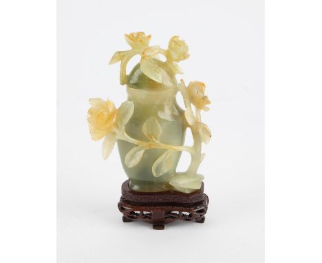 Chinese jade lidded jar decorated with carved flowers and vines. 20th century 12 cm High. Comes with a wooden stand.
