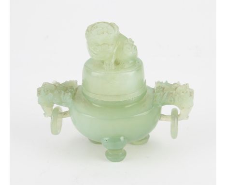 A Chinese Xiu Jade Tripod censer. Decorated with Foo dog finial and Foo dog head handles to sides with relief carved rings. H