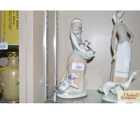 A Lladro figurine of a girl carrying kittens