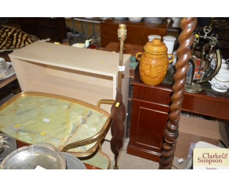 A teak standard lamp lacking shade