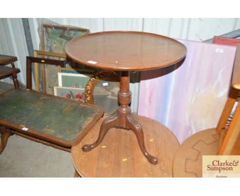A circular mahogany snap top tripod table on carve dbase