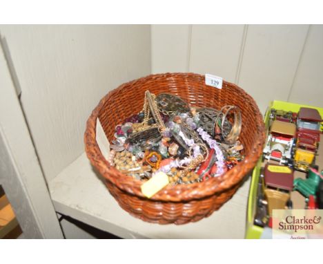 A wicker basket and contents of various costume jewellery to include beads; bangle etc