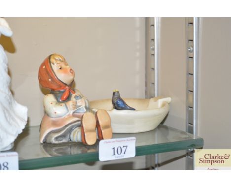 A Goebel figure of a girl knitting beside a bird bath