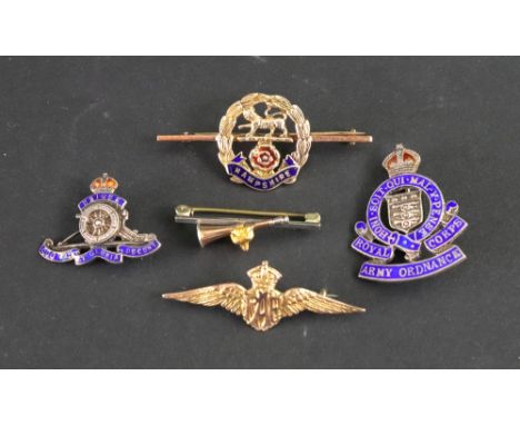 A collection of mostly military badges, including a gold plated RAF winged badge, a silver and enamel Army Ordnance badge, a 