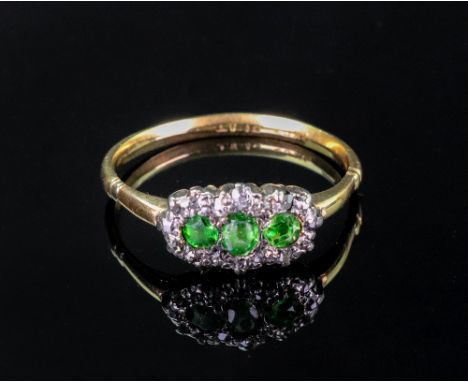 A gold, green gemset and diamond three stone cluster ring, the three green gemstones set within a surround of rose cut diamon