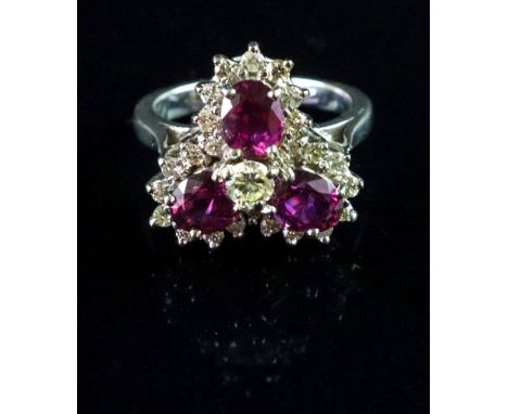 A diamond and ruby dress ring, the trefoil cluster centred by a modern cut brilliant and three oval cut rubies within a singl