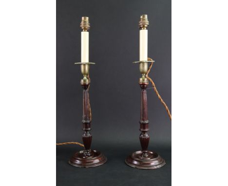 A pair of George III style mahogany candlestick table lamps, the reeded and ring turned columns with brass vase shape sconces