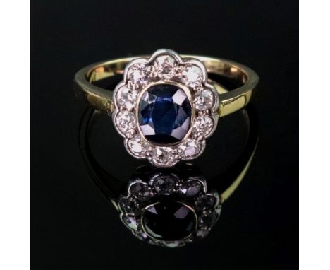 A gold, sapphire and diamond oval cluster ring, collet set with the cushion shaped sapphire to the centre in a surround of te