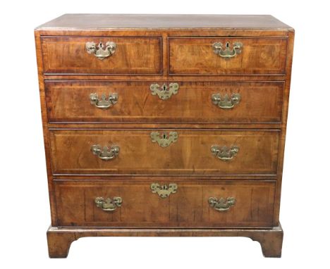 A George II walnut cross and feather banded chest, the moulded rectangular caddy top above two short and three long drawers, 