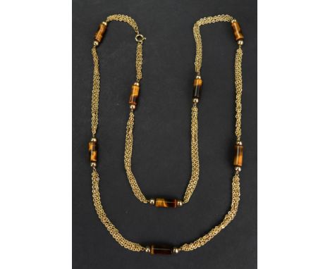 A gold and tiger's eye necklace, in a three row oval chain link design, spaced with tiger's eye batons, with pairs of beads a