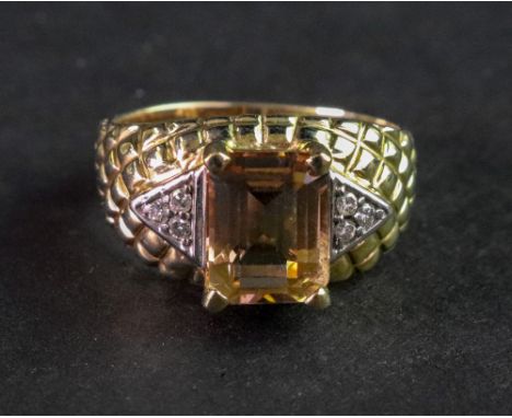 A 9ct gold, citrine and diamond ring, claw set with a rectangular step cut citrine to the centre, between diamond three stone