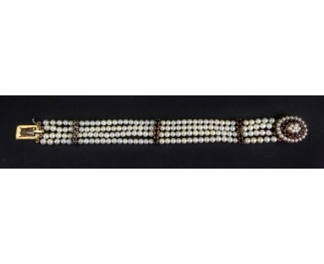 A gold, garnet and cultured pearl bracelet, formed as four rows of cultured pearls, with three garnet set five stone division