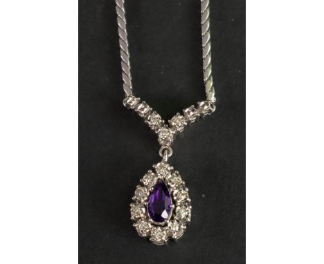A white gold, amethyst and diamond set pendant necklace, the pear cut amethyst claw set within a diamond surround, suspended 