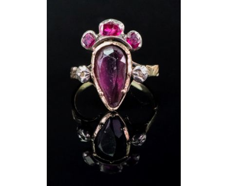 An 18th century ring with pear shaped amethyst, 'crowned' by three garnets in foiled close collet settings, the shoulders wit