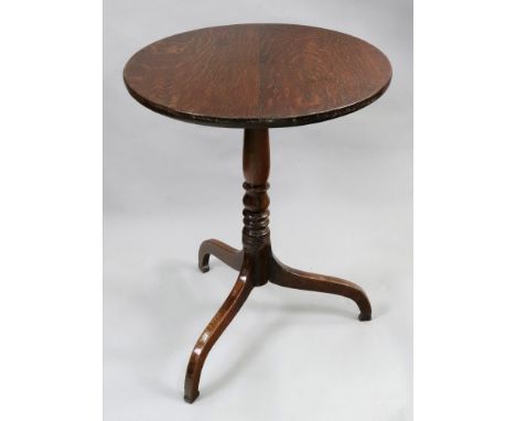 A George III oak pedestal table, the circular tilt-top on a ring and baluster turned pillar and arched tripod base, 49cm diam