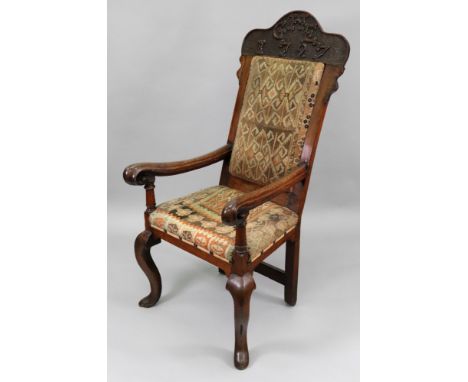 An early 18th century oak elbow chair, the high back with arched cresting carved with initials and date 'GHE 1726', the back 