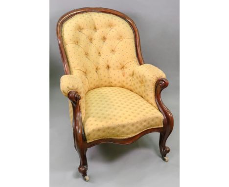 A Victorian moulded mahogany frame button down upholstered armchair, circa 1860, with scroll arms, on cabriole legs and casto