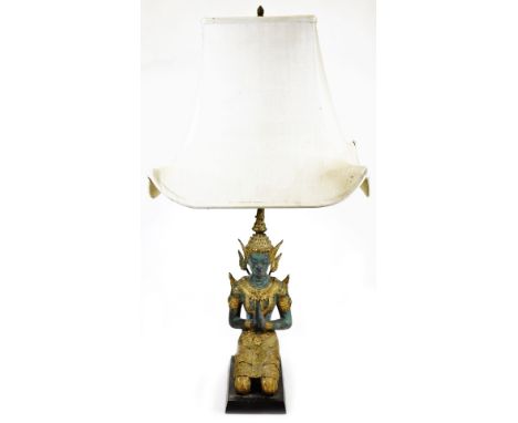 A Thai table lamp formed as a kneeling figure, in metal with elaborate head dress and clothing, on wooden base with modern el