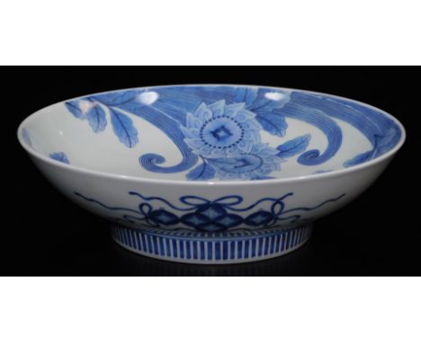 A large Japanese porcelain underglaze blue and white Nabeshima dish, decorated with stylised peonies and scrolls, the reverse