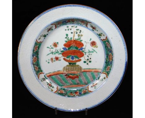 An 18thC Chinese porcelain plate, decorated with central panel of a vase of flowers in blue, green and red, within enamelled 