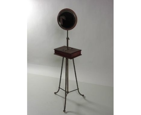 An Edwardian brass and mahogany Shaving Mirror Stand, with circular bevelled plate, on tripod base. (1)