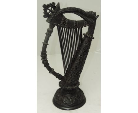 A tall and rare 19th Century Irish bog oak Harp, profusely carved in the Celtic style with scrolling shamrock, ivy leaves and