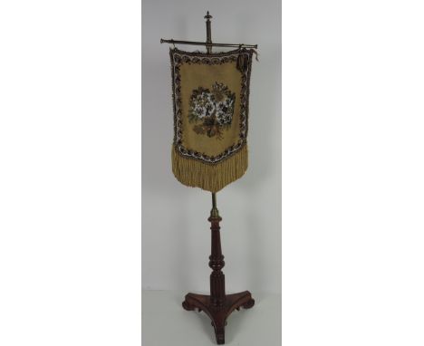 A Regency period Polescreen, the adjustable brass pillar with tapestry and bead work screen, on a satinwood tri-form base wit
