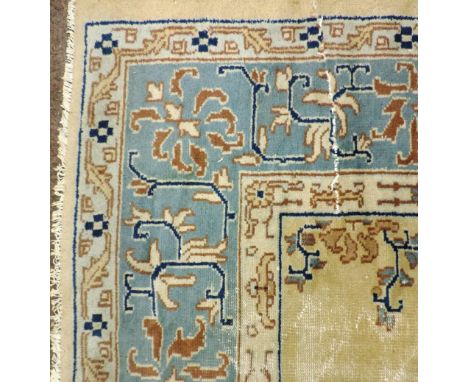 A large fawn ground antique Carpet, with decorated large blue border, approx. 366cms x 275cms (12' x 9'). (1)