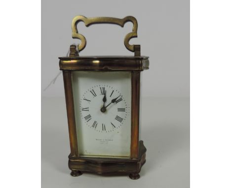 A small late 19th Century French shaped brass Carriage Clock, the enamel dial with Roman numerals, signed Mackay & Chisholm, 